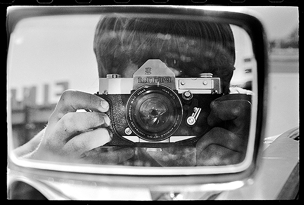 Petri camera reflection in a car mirror